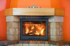 gas fireplace with stone surround with orange wall