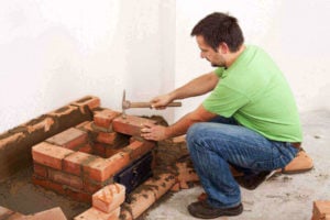 man laying down bricks