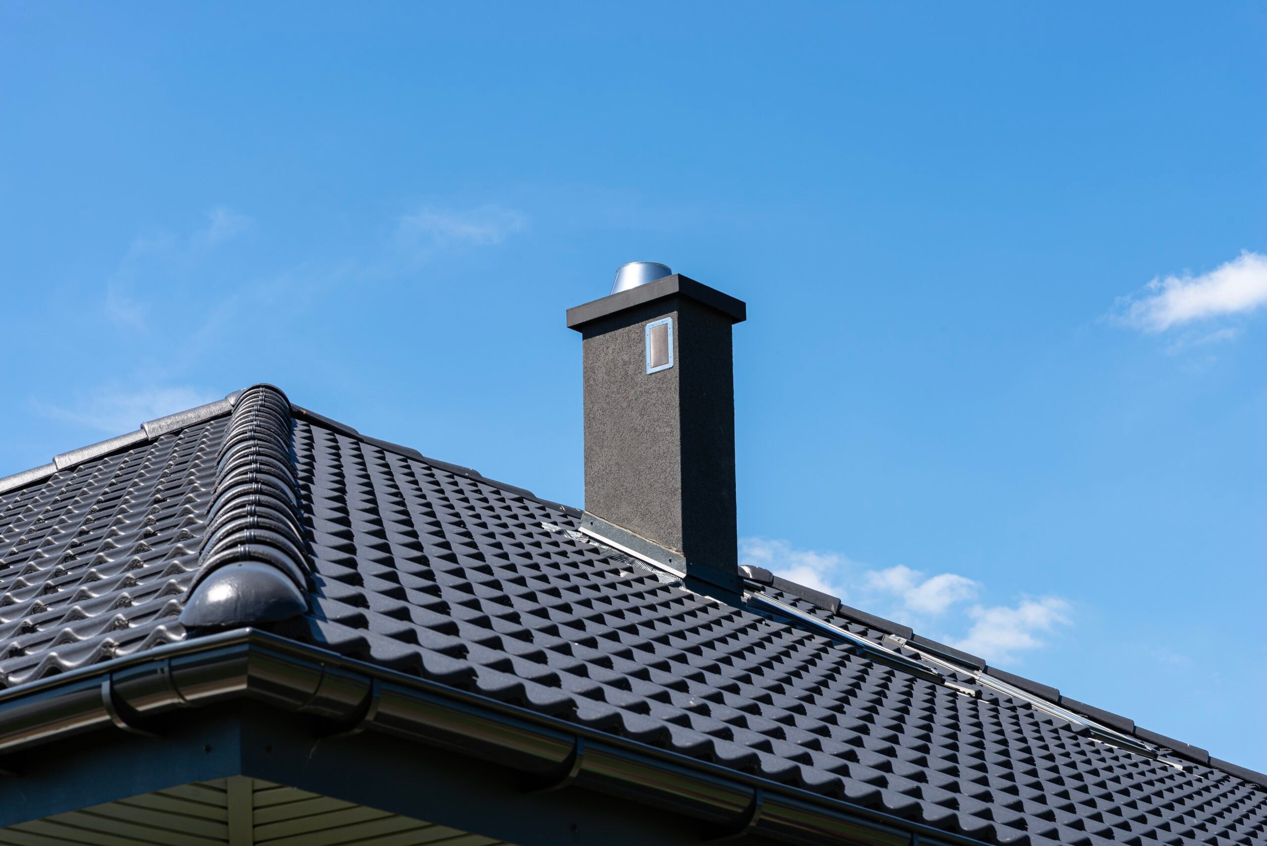 Modern roof with gutter and chimney during summer